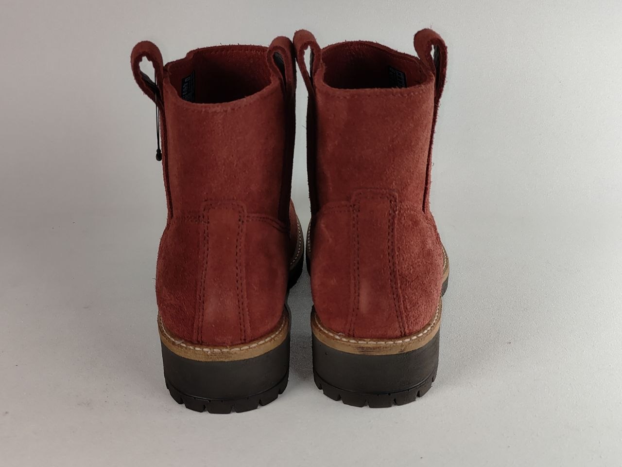 A pair of women's ankle boots in reddish-brown suede, shown from the back against a light gray background.