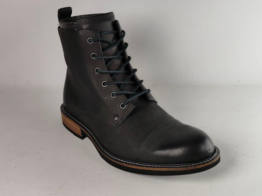 A single black leather lace-up ankle boot with a rounded toe, dark laces, metal eyelets, and a low stacked heel, photographed on a light gray studio background.