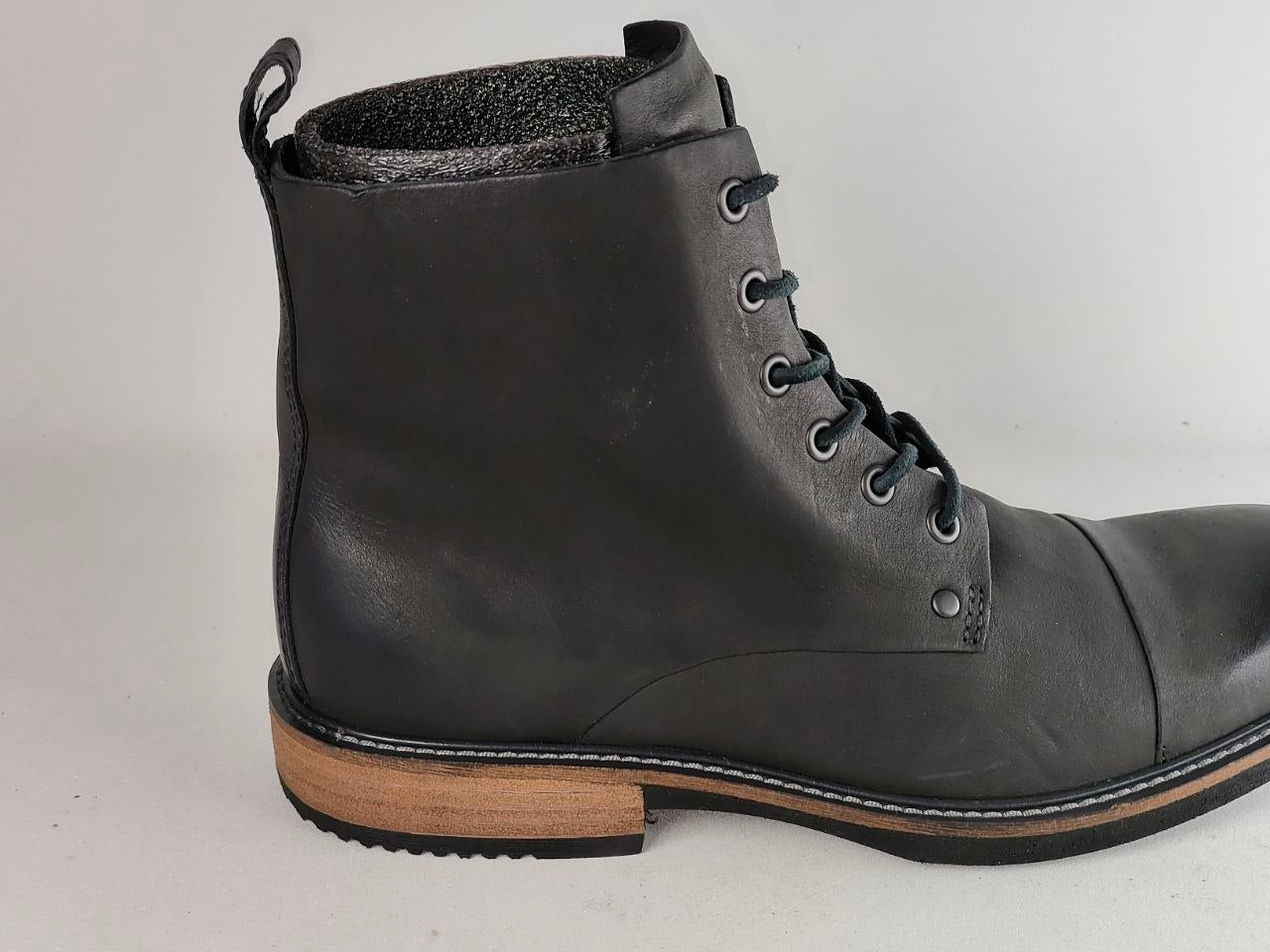A single black leather lace-up ankle boot with a tan stacked heel and black sole, photographed against a light gray background.