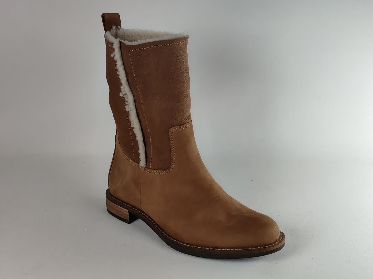 A brown suede ankle boot with a white shearling lining, shown from a side profile against a light gray background.