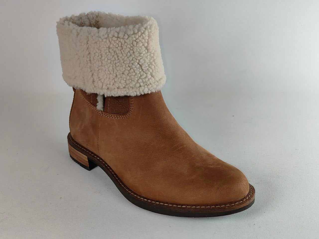 A brown suede ankle boot with a thick cream-colored shearling-style fleece cuff, shown from a three-quarters angle on a light gray background.