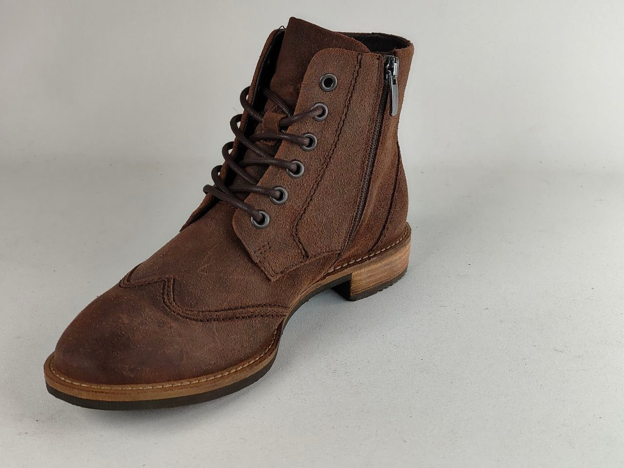 A brown suede lace-up ankle boot with a side zipper, brown laces, and a stacked wood-look heel, shown on a light gray background.