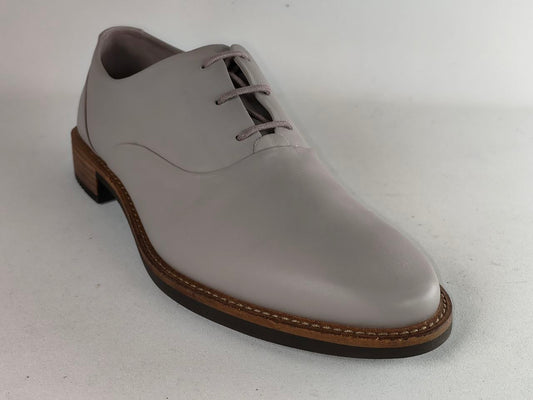A light gray leather lace-up dress shoe with a brown stacked sole, photographed on a neutral light gray background.