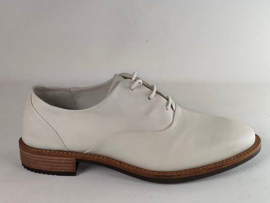 A single white leather lace-up dress shoe with a brown stacked heel and dark outsole, shown from a side profile against a light gray background.