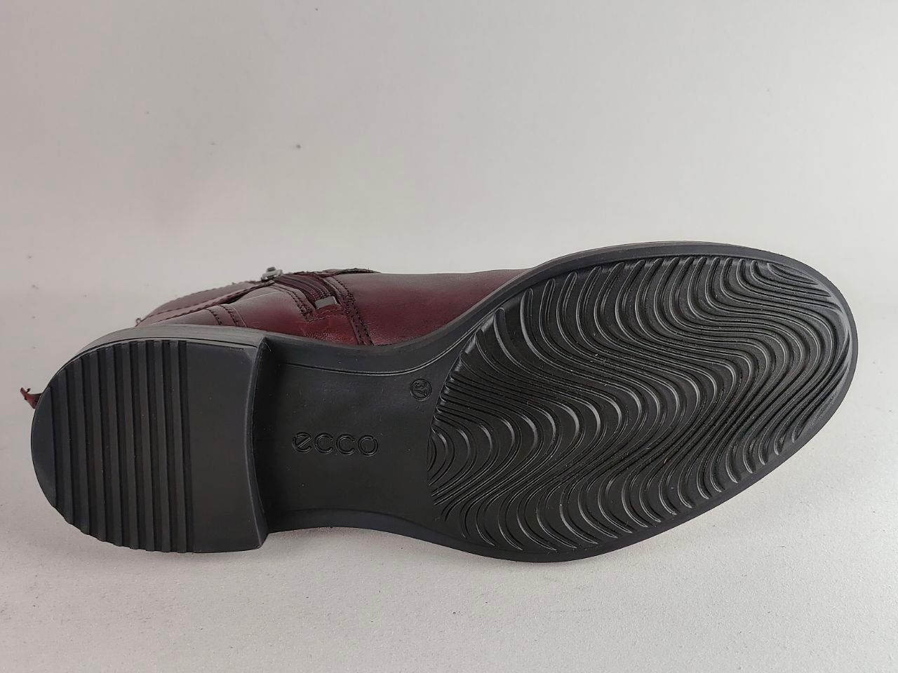The outsole of a dark brown leather boot with a black treaded rubber sole, showing the embossed 'ecco' brand logo.