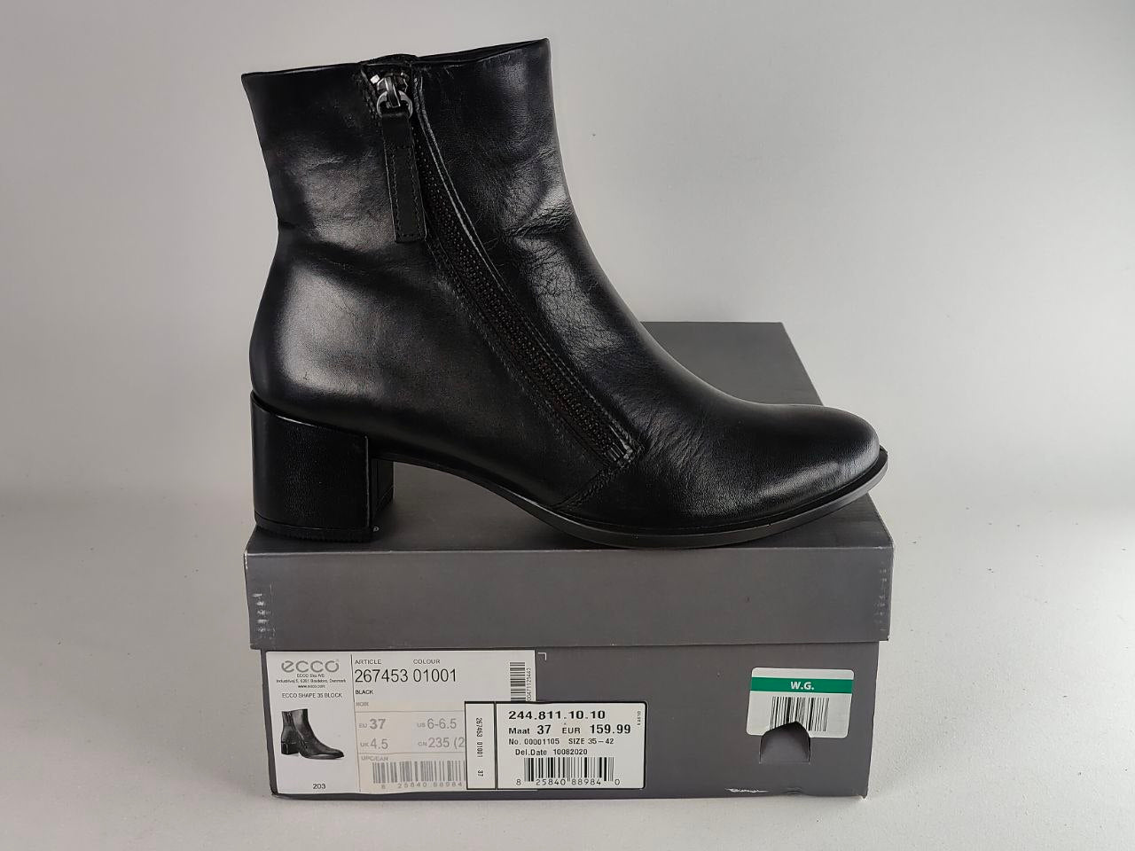 A black leather ankle boot with a block heel and side zipper, displayed on top of its gray ECCO shoebox against a light gray background.