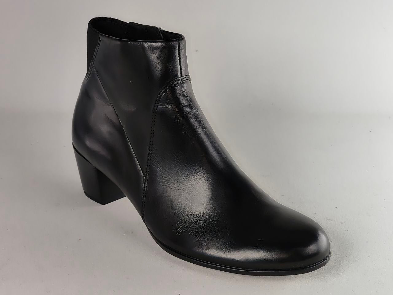A black leather ankle boot with a low block heel, shown from a three-quarters angle against a light gray background.