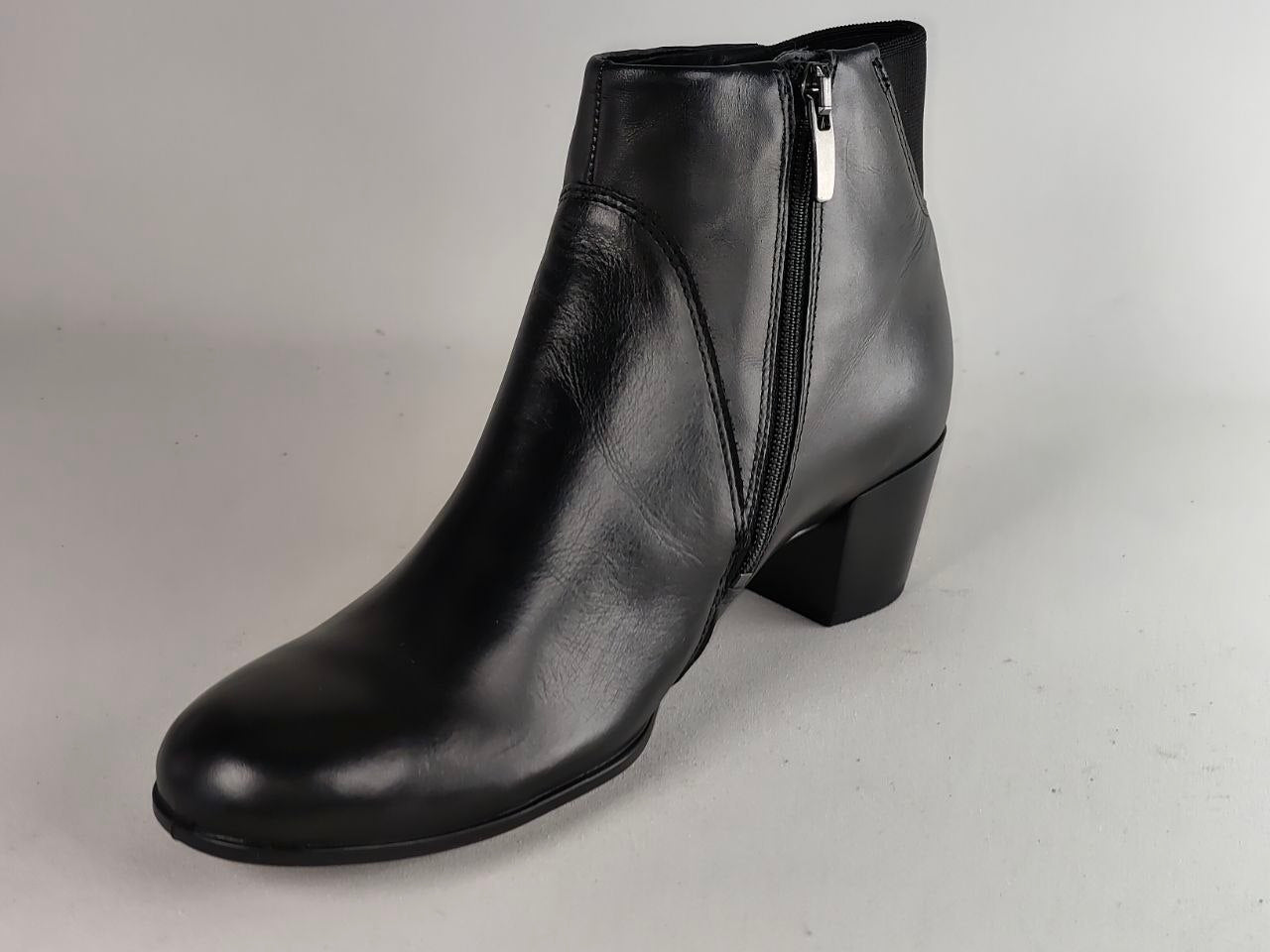 A black leather ankle boot with a side zipper, shown from a three-quarters angle on a neutral gray background.