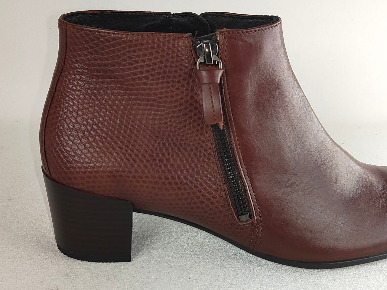 A brown leather ankle boot with a textured python-style embossed pattern on the side, a black zipper, and a low block heel, shown against a plain light background.