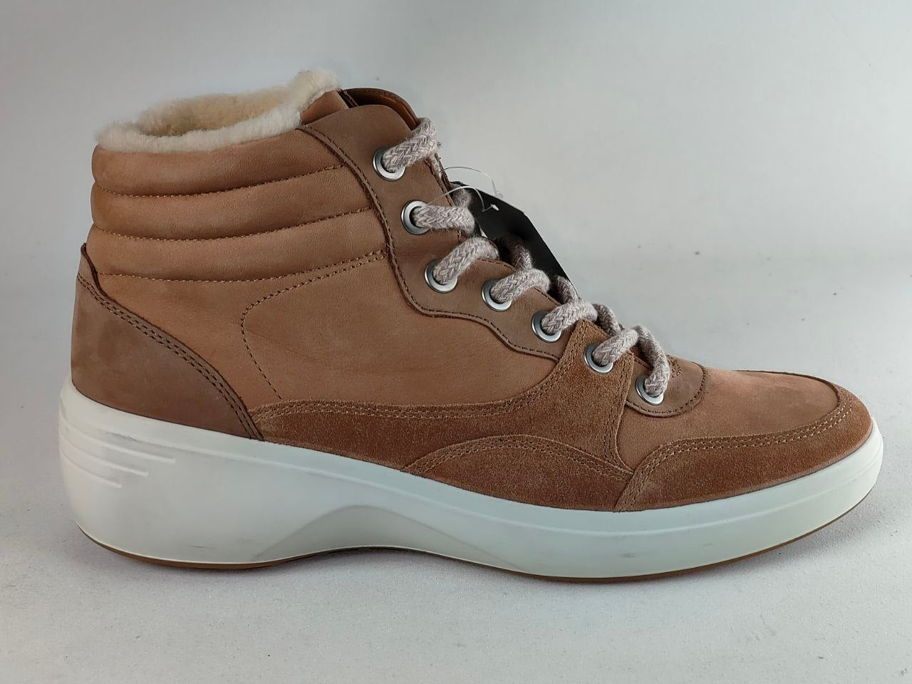 A brown suede and fabric high-top sneaker boot with a white sole and light gray laces, featuring a soft white faux-fur lining visible at the collar.