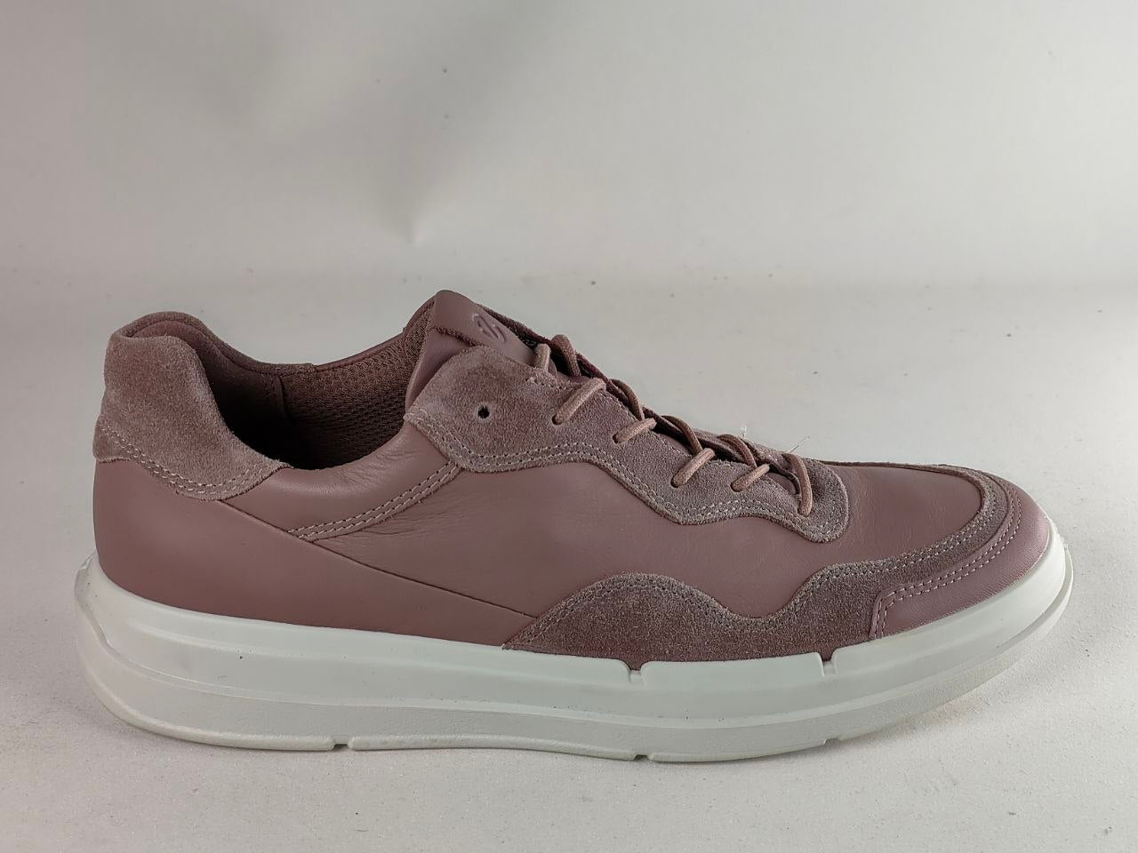 A single low-top sneaker in a dusty mauve-brown colorway, featuring mixed leather and suede panels, matching laces, and a thick white platform sole, shown against a plain light gray background.