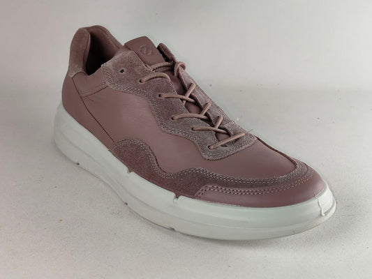 A single low-top sneaker in a dusty mauve-brown color, featuring a mix of smooth leather and suede panels, matching laces, and a thick white platform sole, photographed on a neutral light gray background.