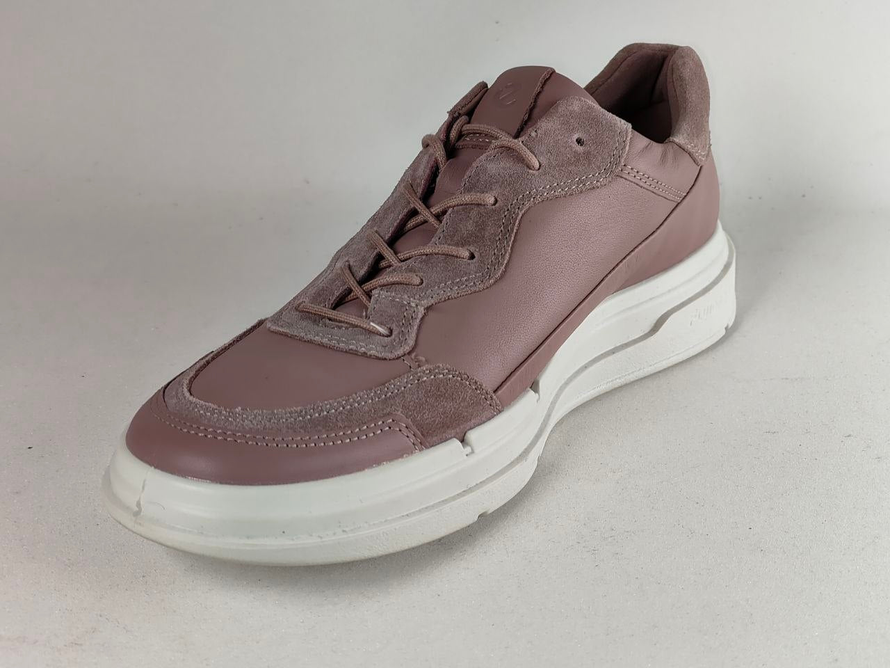 A single low-top lace-up sneaker in a dusty mauve-brown color, featuring a mix of smooth leather and suede panels, a thick white platform sole, and matching laces, photographed on a neutral light gray background.