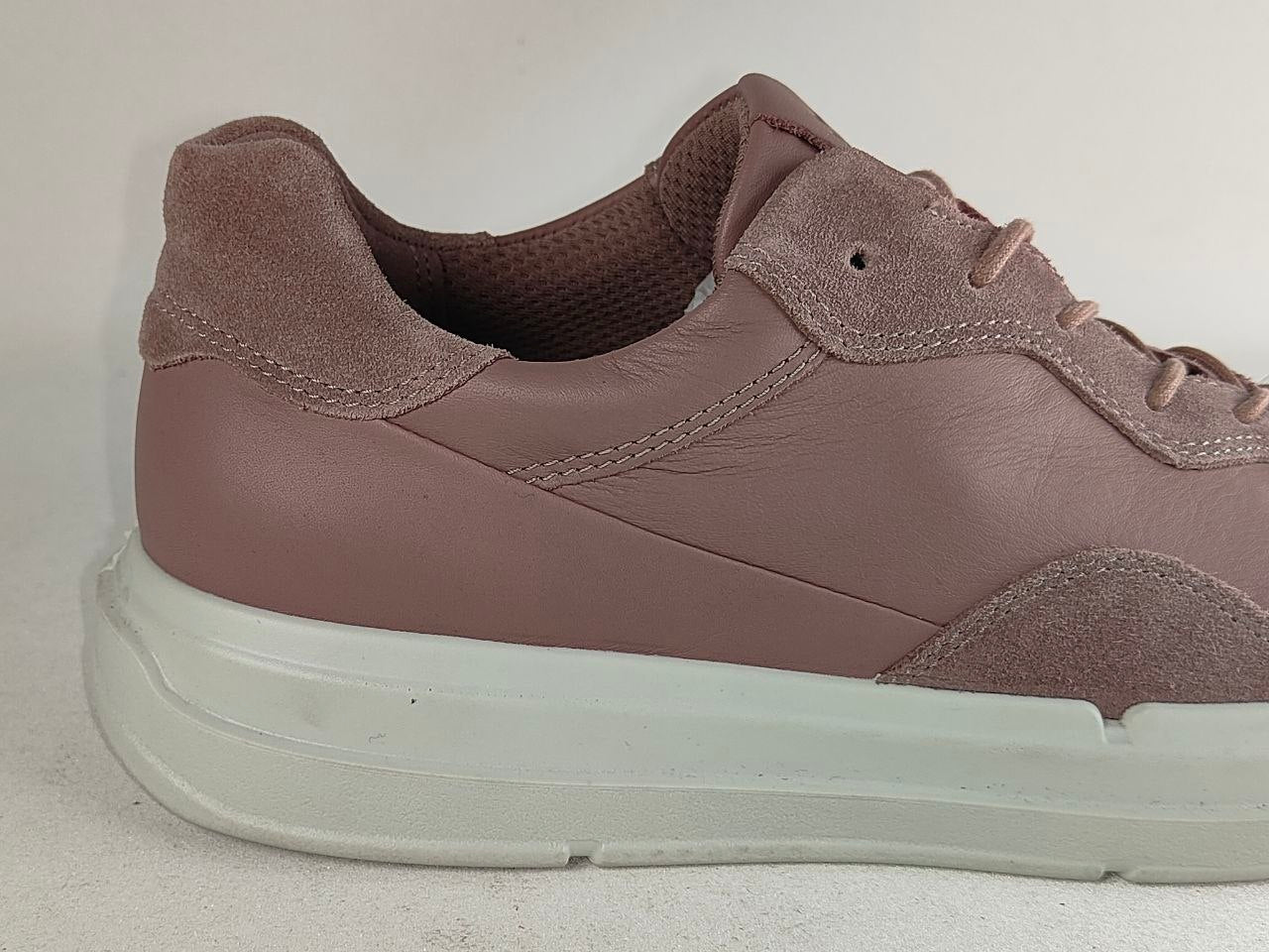 A low-top sneaker in a dusty mauve-brown color, featuring a mix of smooth leather and suede panels, matching laces, and a thick white platform sole.