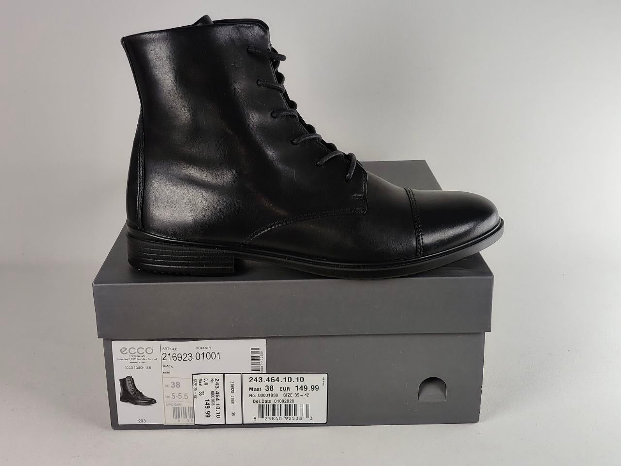 A black leather lace-up ankle boot by ECCO, displayed on top of its dark gray shoebox against a neutral light gray background.
