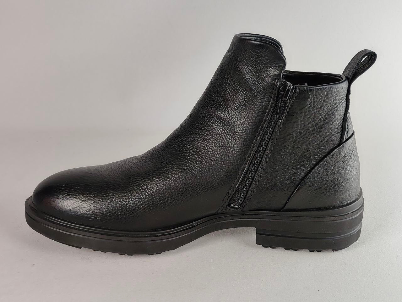 A single black pebbled leather ankle boot with a side zipper, low block heel, and pull tab, shown from a side profile against a neutral gray background.