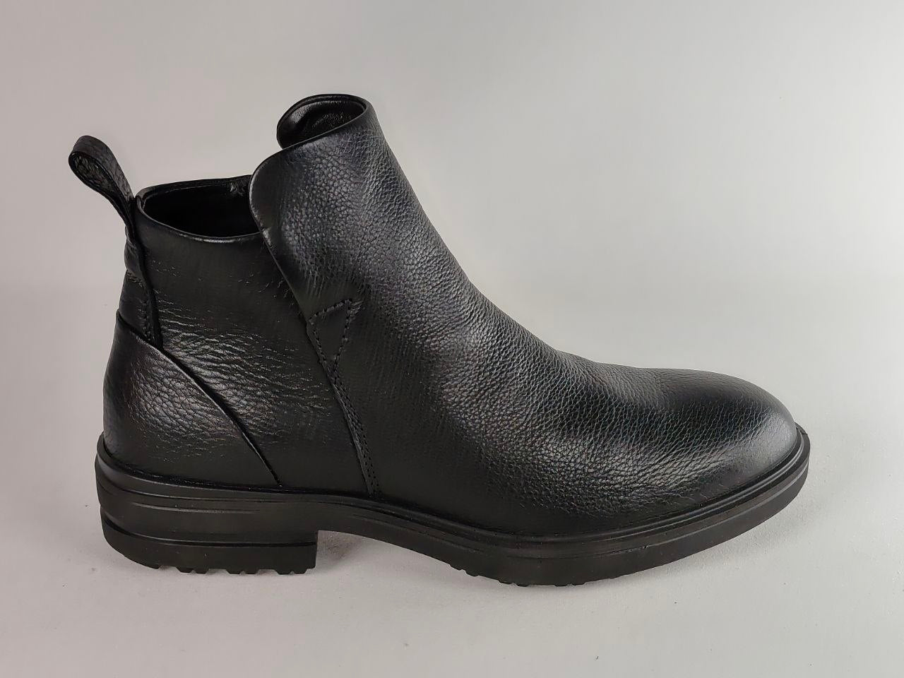 A black pebbled leather ankle boot with a low block heel and a pull tab, shown from a side profile view against a light gray background.