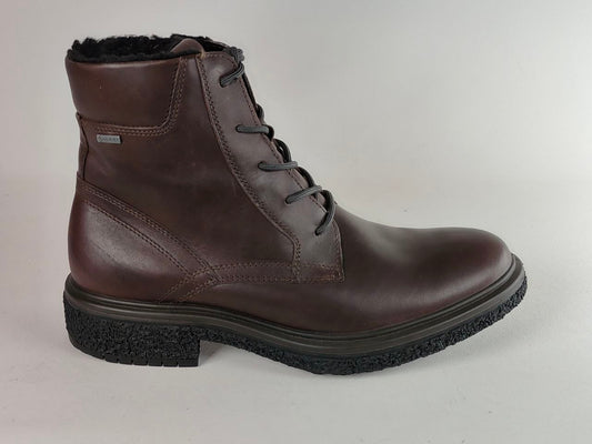 A dark brown leather lace-up ankle boot with a black textured sole and a black faux-fur lining visible at the top, shown against a light gray background.