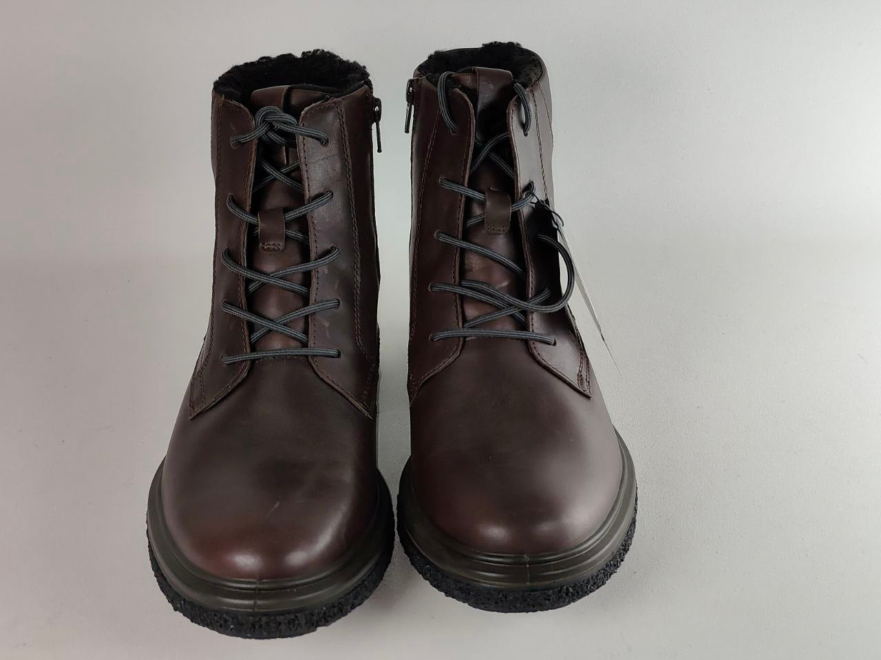 A pair of dark brown leather lace-up ankle boots with black soles and a black fuzzy lining, shown against a plain light gray background.