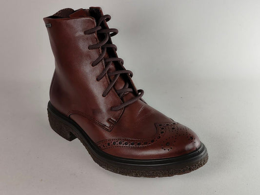A dark brown leather lace-up boot with decorative brogue perforations on the toe and a dark sole, photographed against a neutral light gray background.