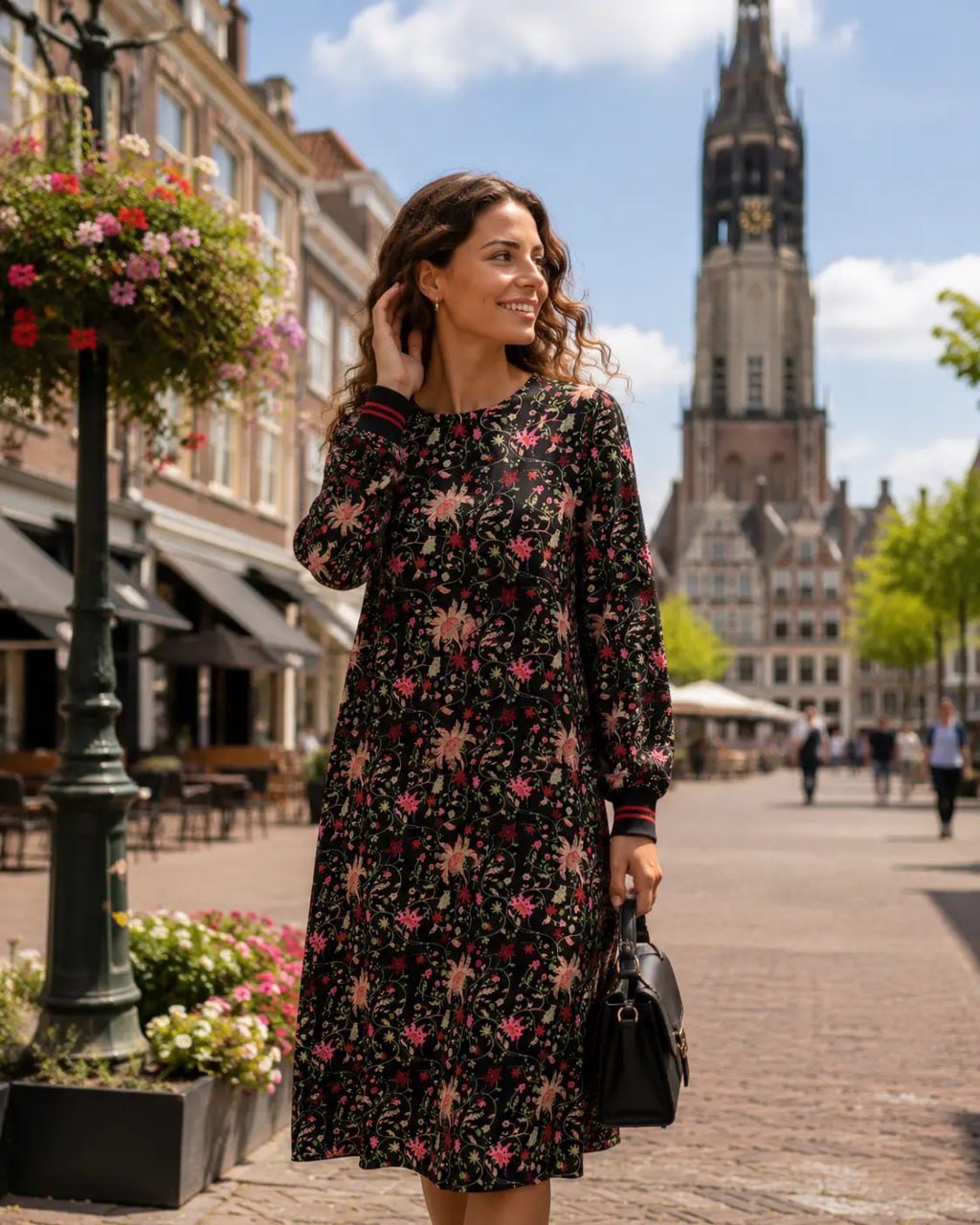 Woman in a floral dress walking on a street with a clock tower in the background