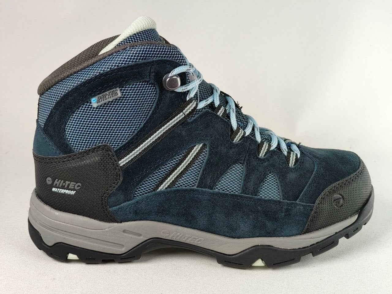 A mid-cut Hike-Tec waterproof hiking boot in navy blue suede and mesh with light blue laces, a gray midsole, and black outsole.
