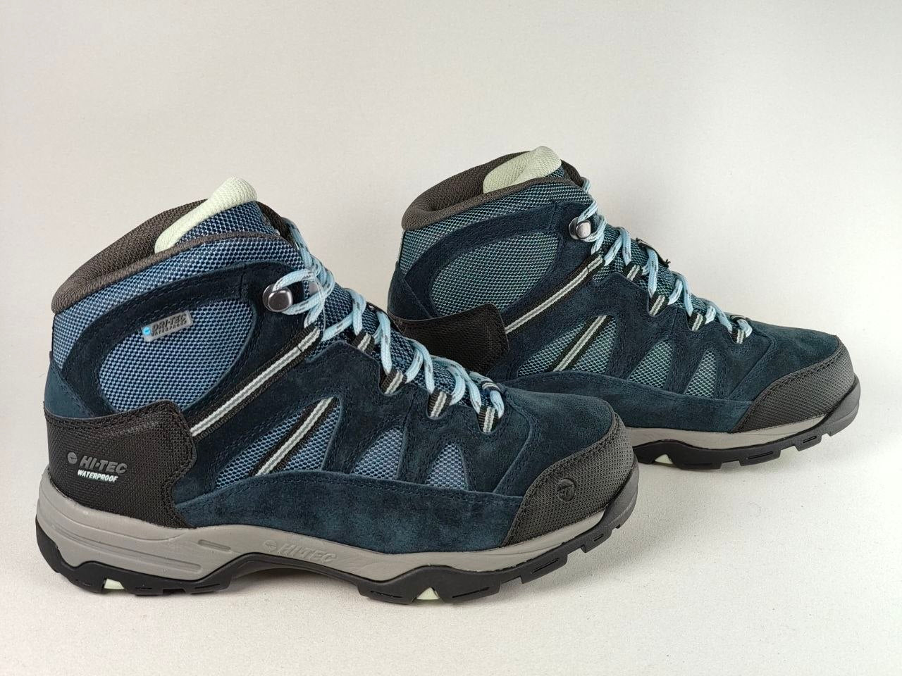 A pair of blue and gray hiking boots with light blue laces, shown on a light gray background.