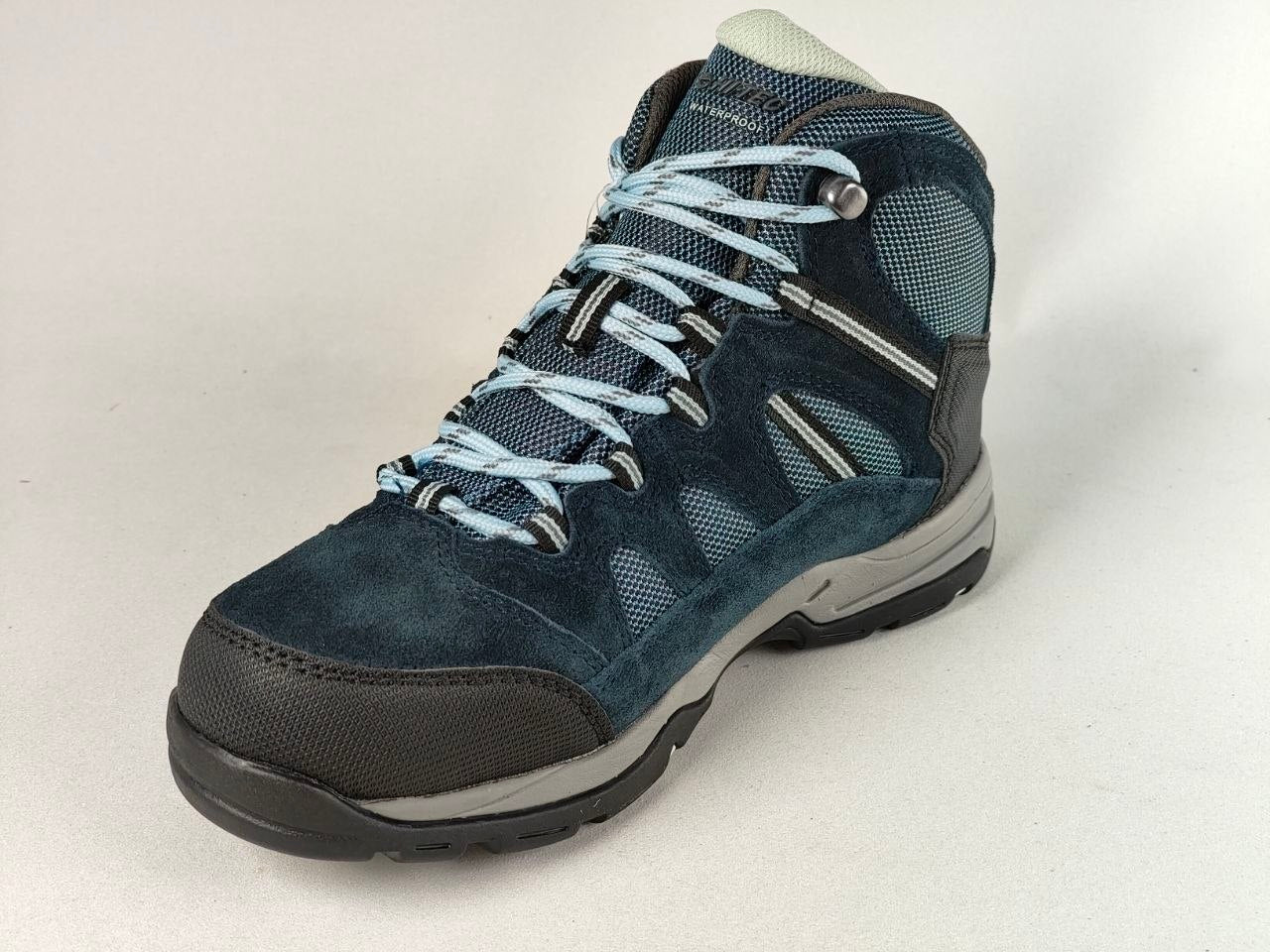 A dark blue suede and mesh hiking boot with light blue laces, a black toe cap, and a gray midsole, shown against a light gray background.