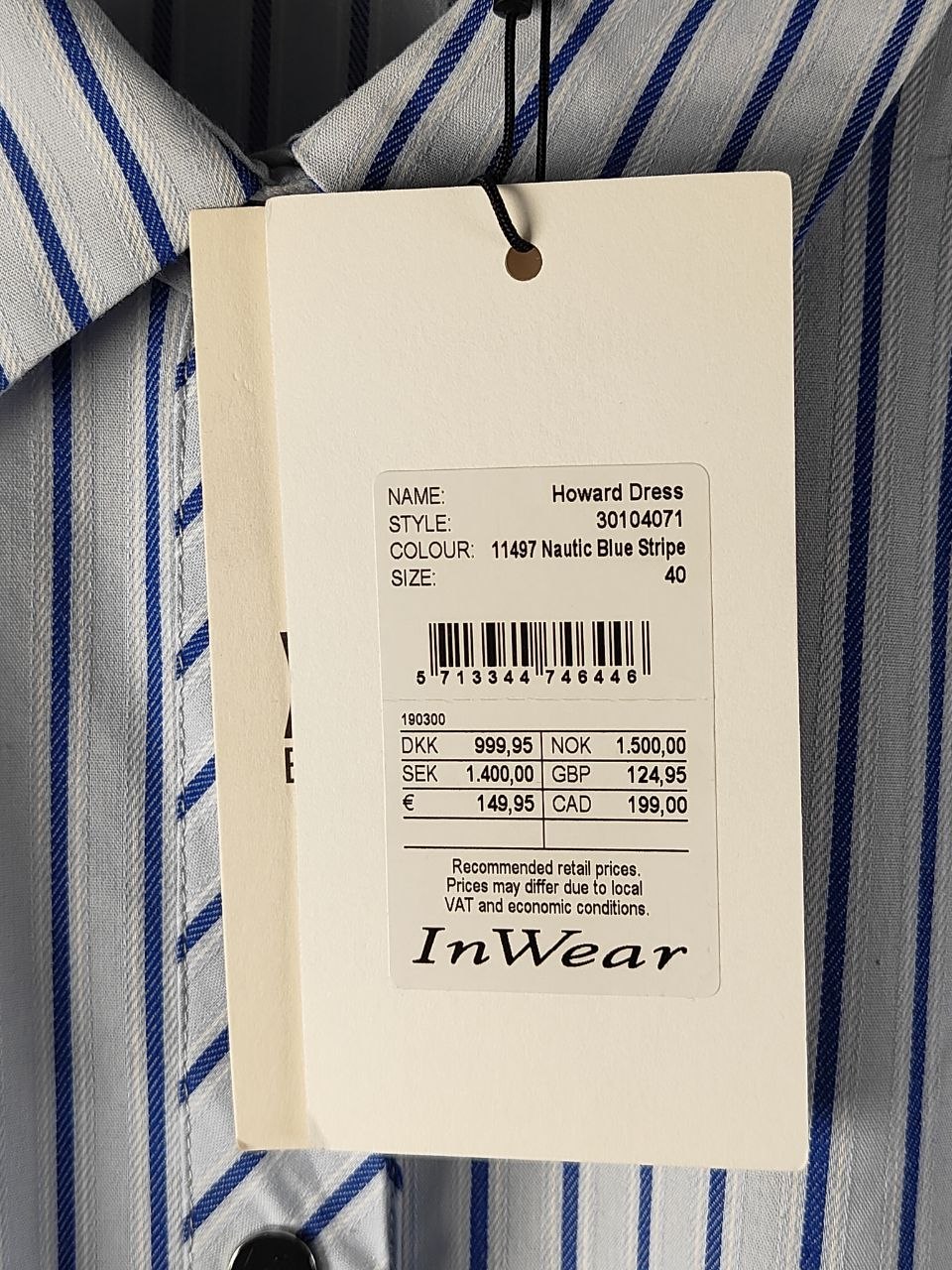 Clothing tag on a striped shirt with product details.