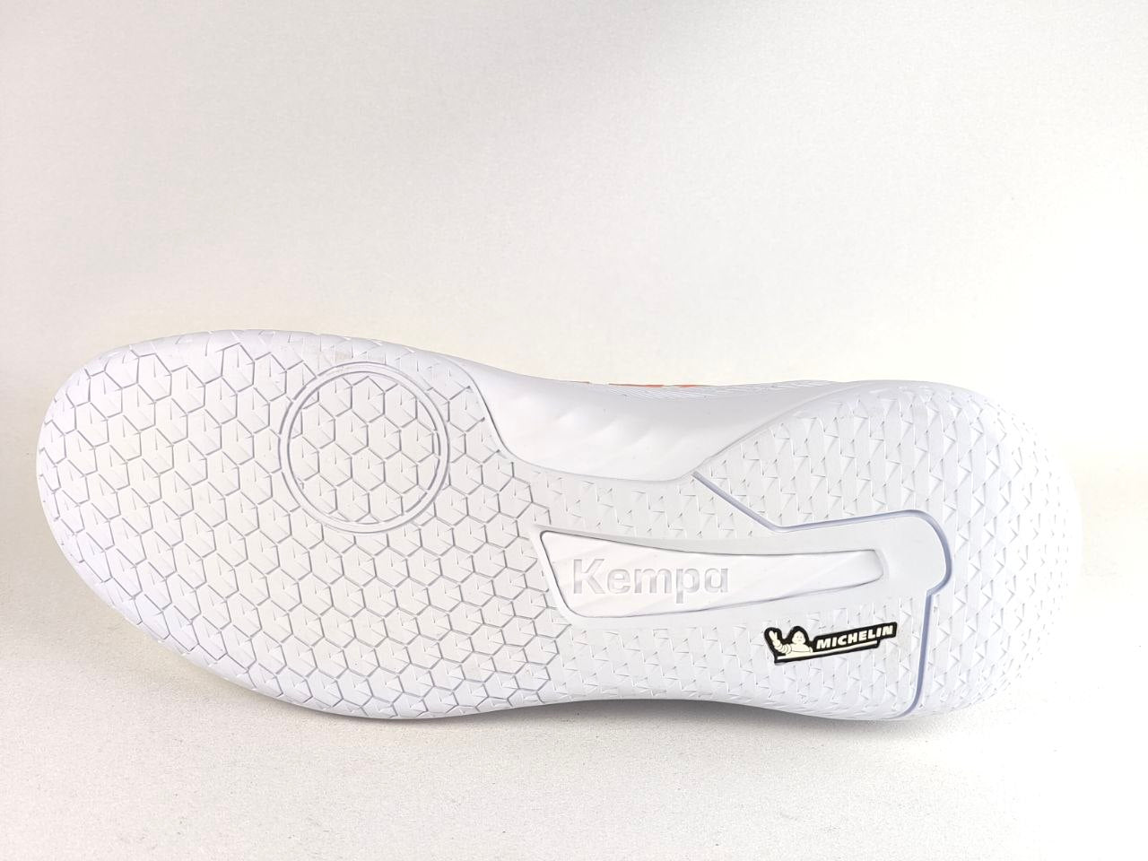 The white outsole of a Kempa indoor court shoe, showing the textured honeycomb pattern, Kempa branding, and a black Michelin logo, photographed on a light gray background.