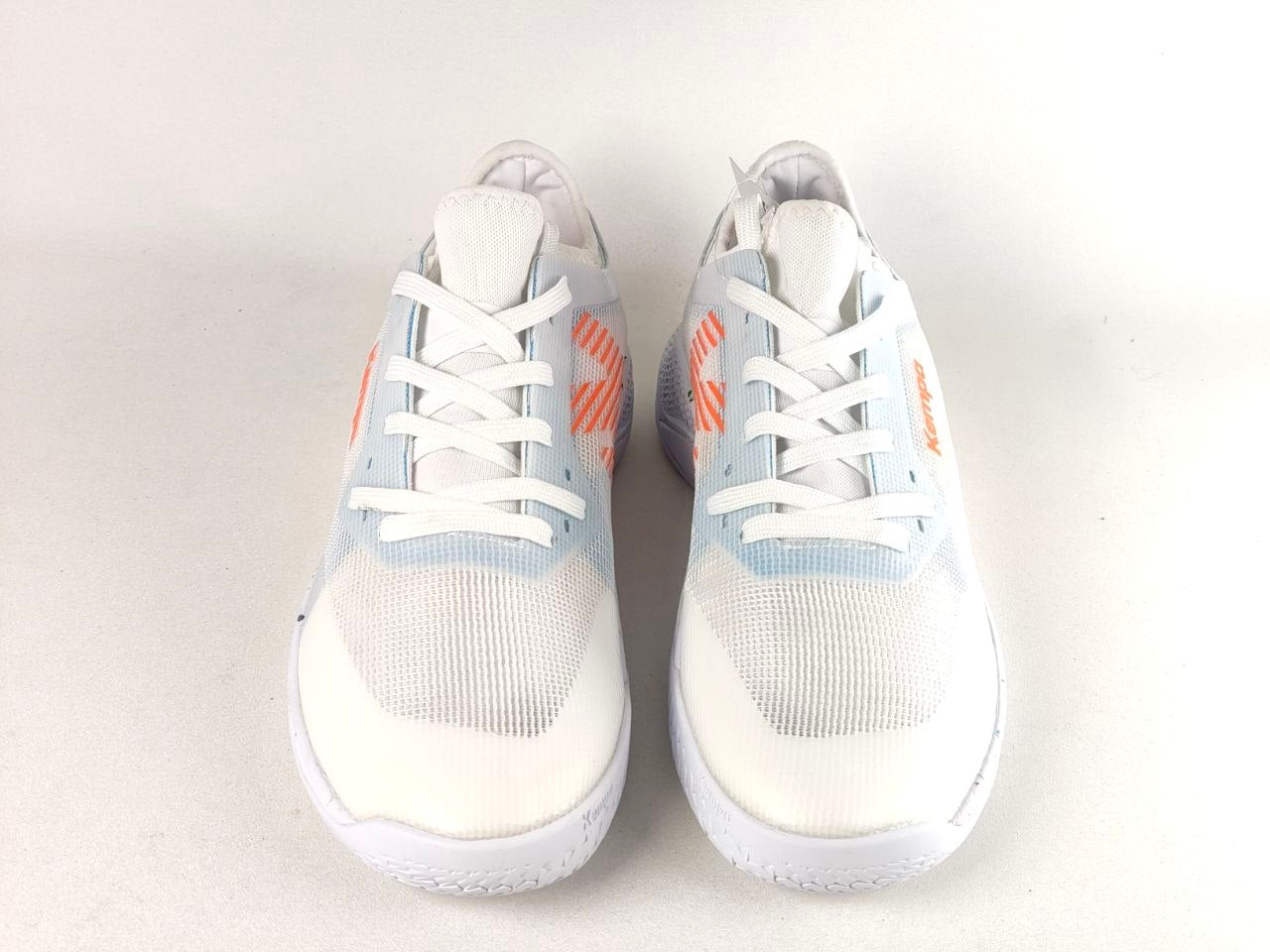 A pair of white athletic sneakers with light blue knit panels and orange side accents, shown from a top-down view on a light gray background.