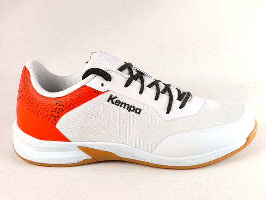 A white and orange Kempa athletic shoe with black laces and a gum outsole, shown from a side profile view against a light beige background.