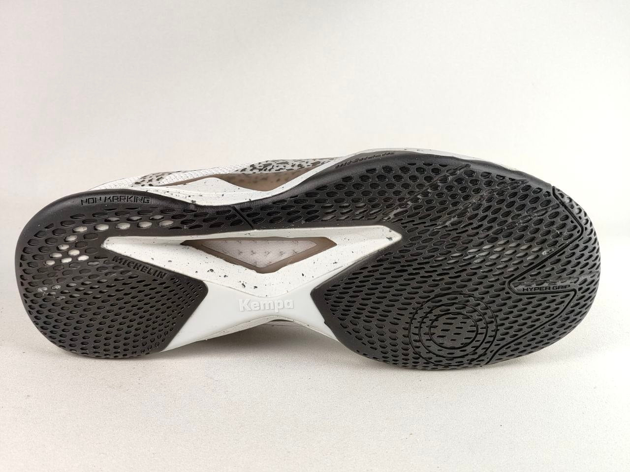 The bottom sole of a Kenda shoe, showing a black textured tread pattern with a white central support structure and a white upper section.