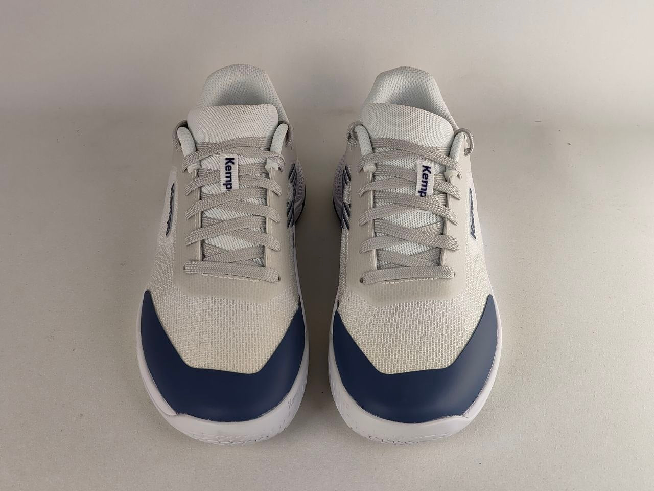 A pair of white and navy blue KEMP athletic sneakers shown from the front on a light gray background.