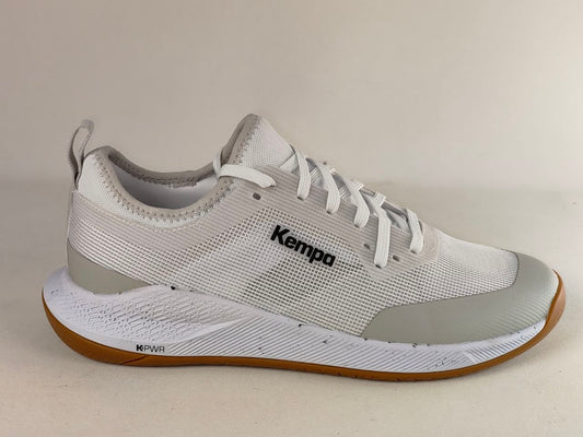 A white and light gray Kempa athletic shoe with a brown outsole, shown from a side profile view against a neutral beige background.