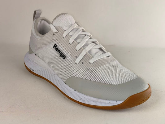 A Kempa brand athletic shoe in light gray and white with a brown gum sole, photographed on a neutral beige background.