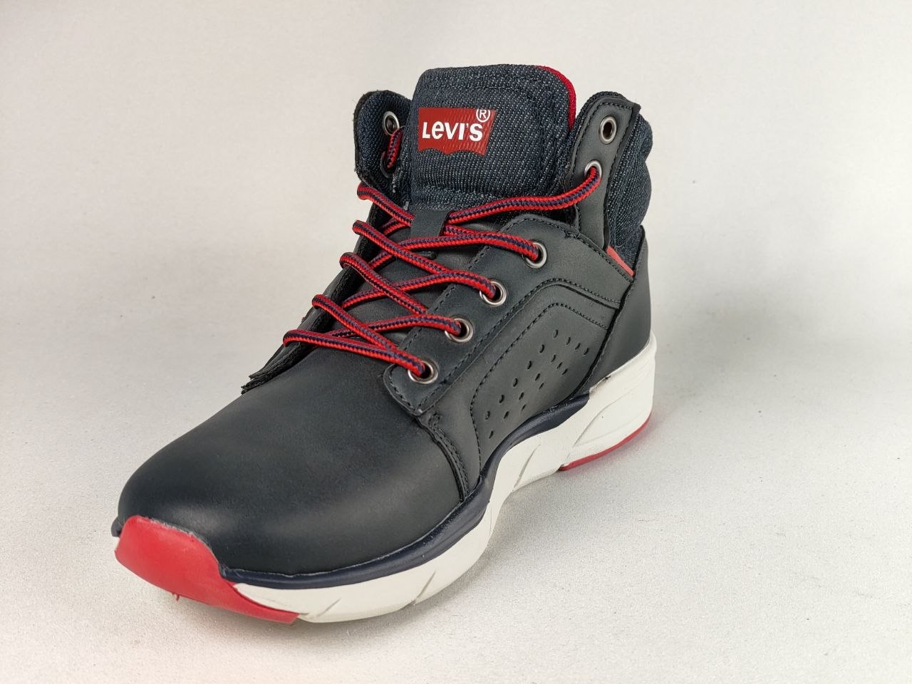 A single Levi's high-top sneaker in dark gray and navy blue with bright red laces, a red toe cap, and a white midsole, photographed on a light gray background.