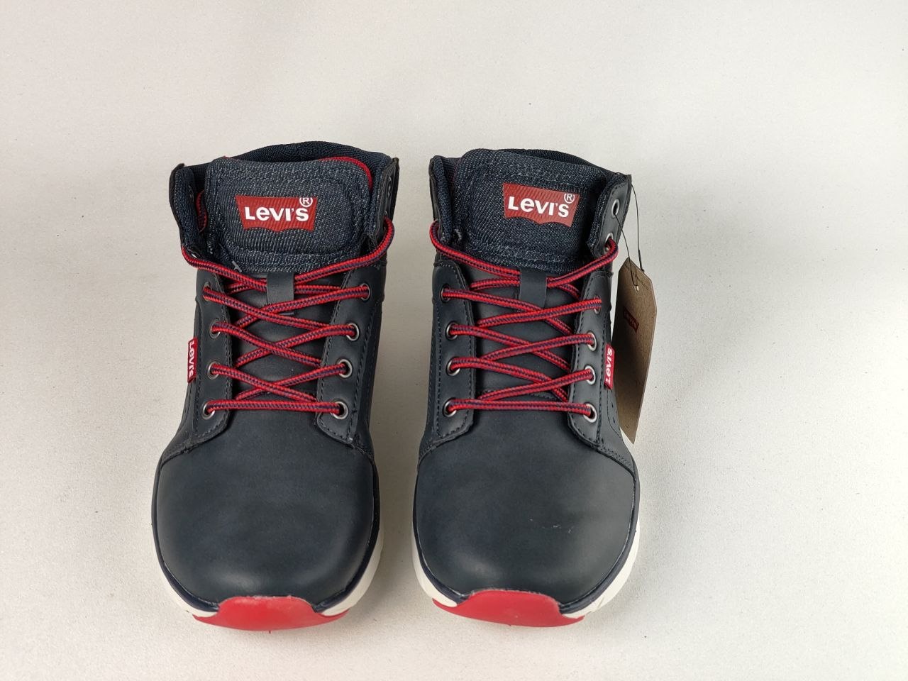 A pair of Levi's high-top work boots in navy blue leather with red laces, red toe caps, and white soles, shown against a plain light background.
