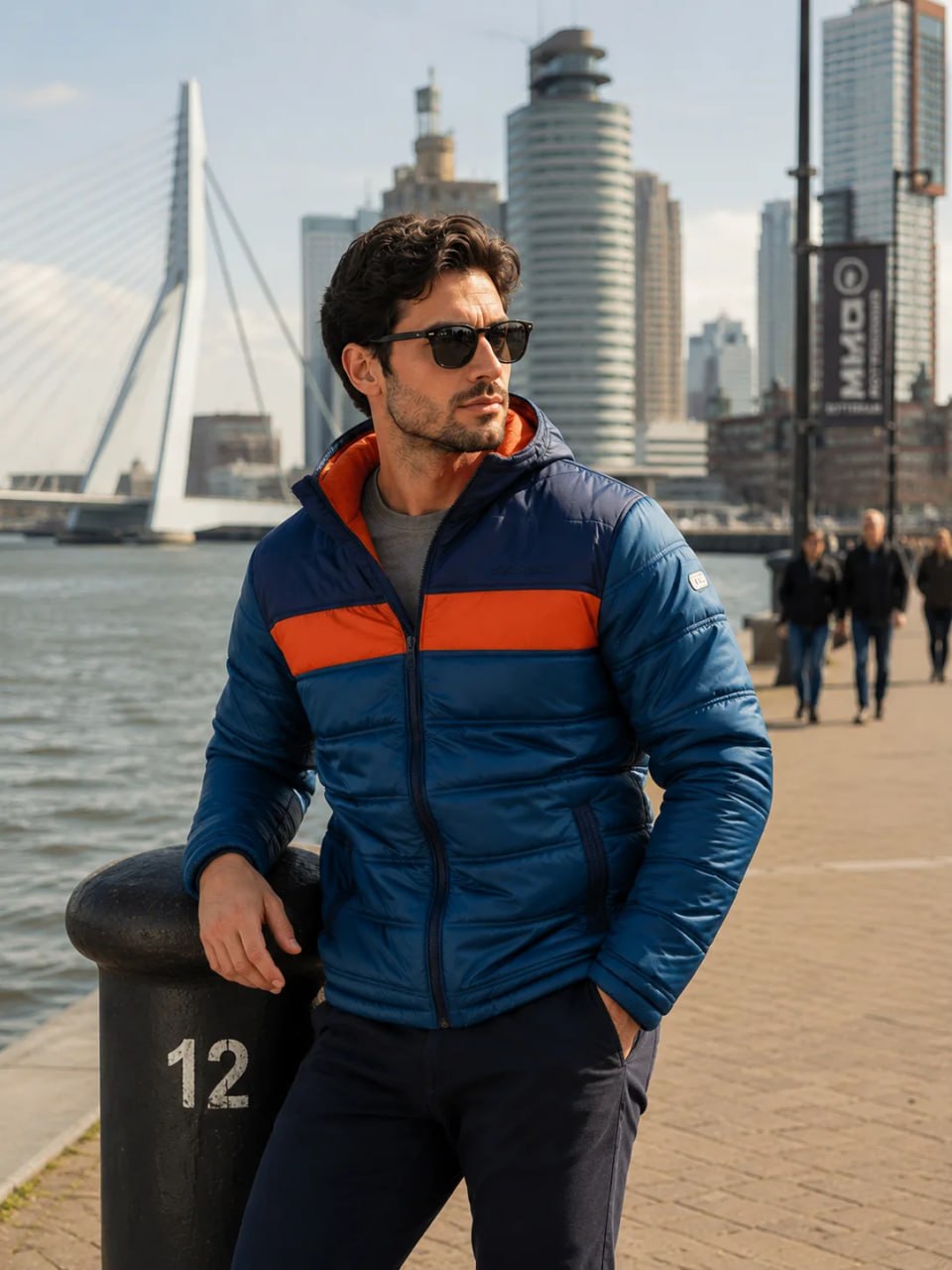 Man wearing a blue and orange jacket with a cityscape in the background