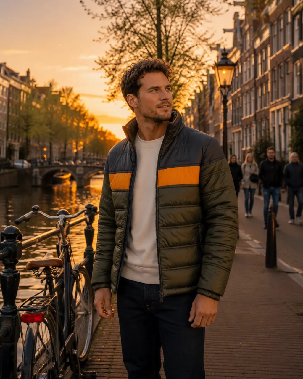 Man standing on a canal side street in a city at sunset