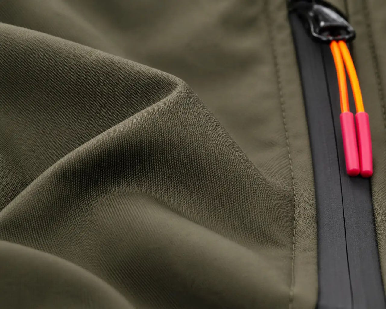 Close-up of a green jacket with a zipper and colorful拉手