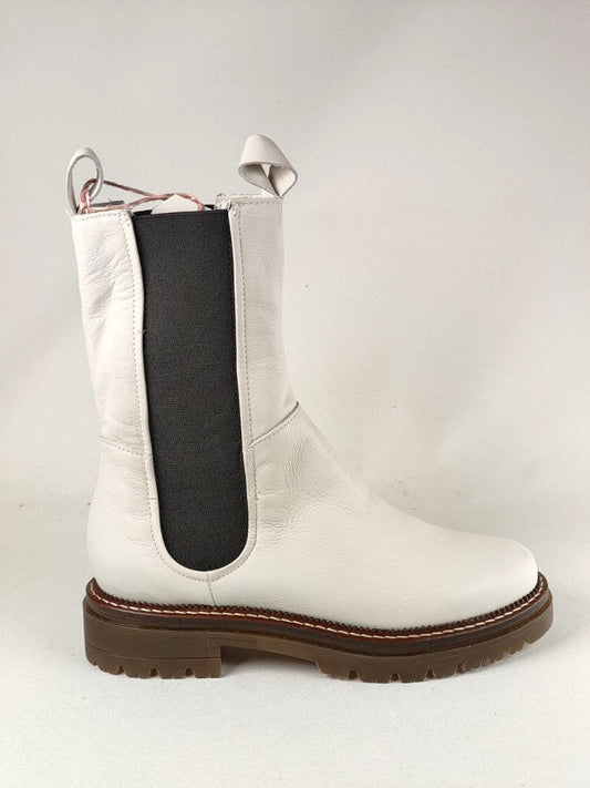 A white leather Chelsea-style ankle boot with a black elastic side panel and a brown lug sole, photographed against a light gray studio background.