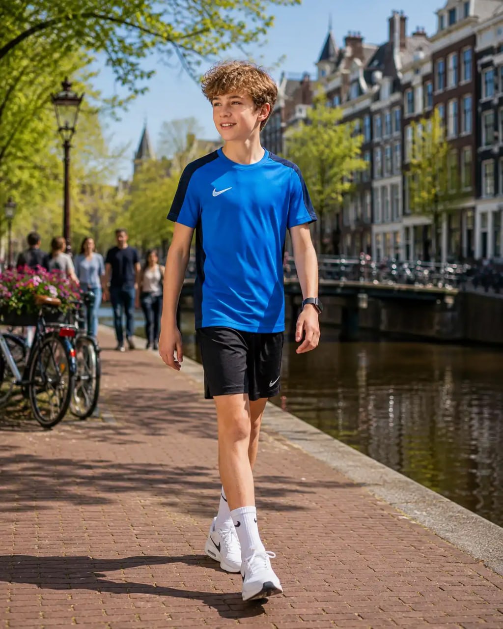 Person walking along a canal with historic buildings in the background