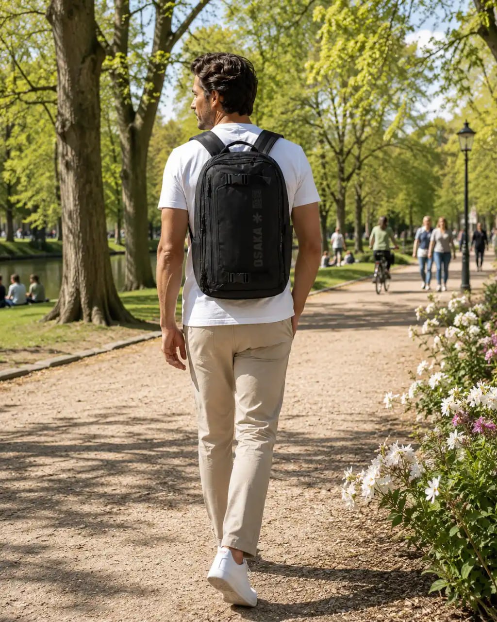 Man walking in a park with a black backpack