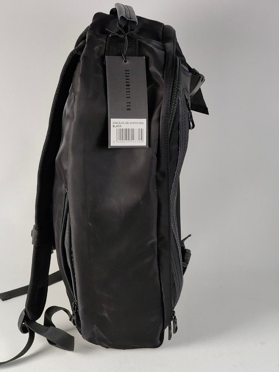 Black backpack with a tag on a light gray background