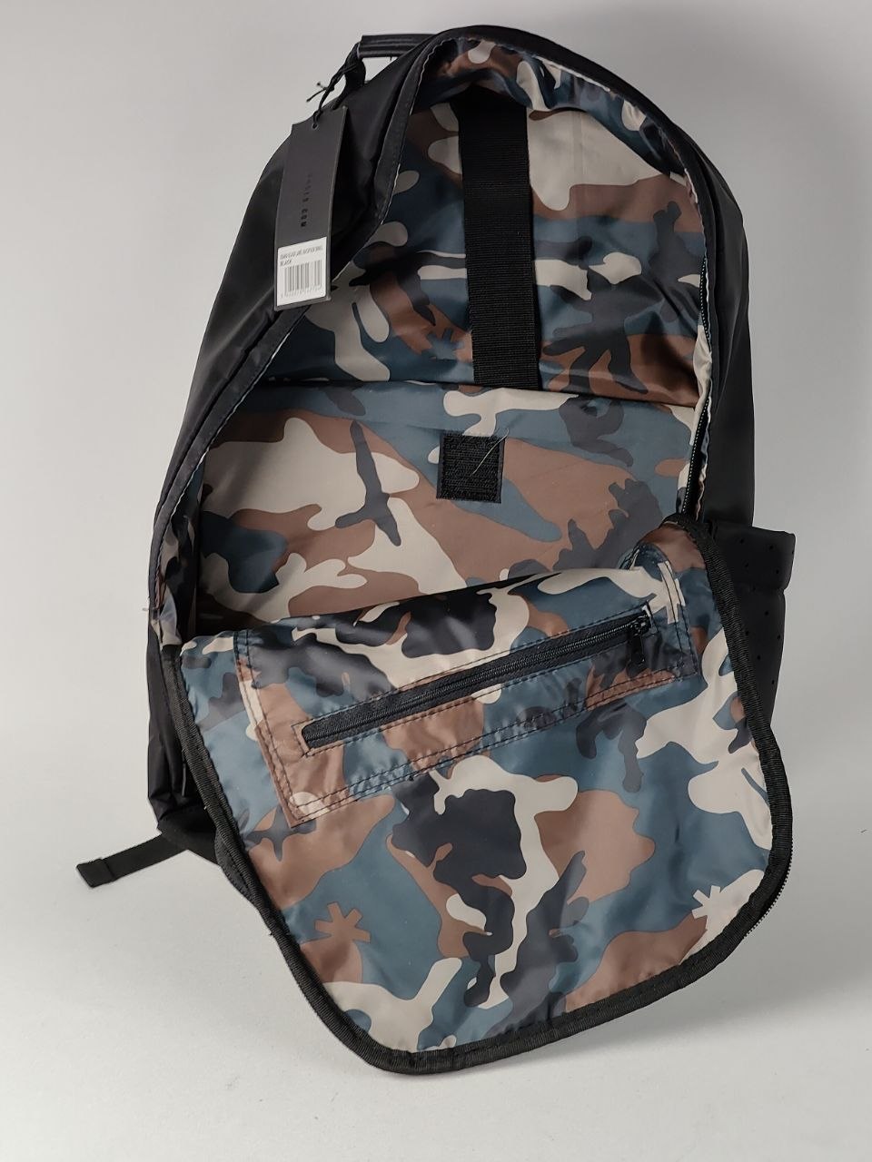 Camouflage backpack with visible brand logo on a gray background
