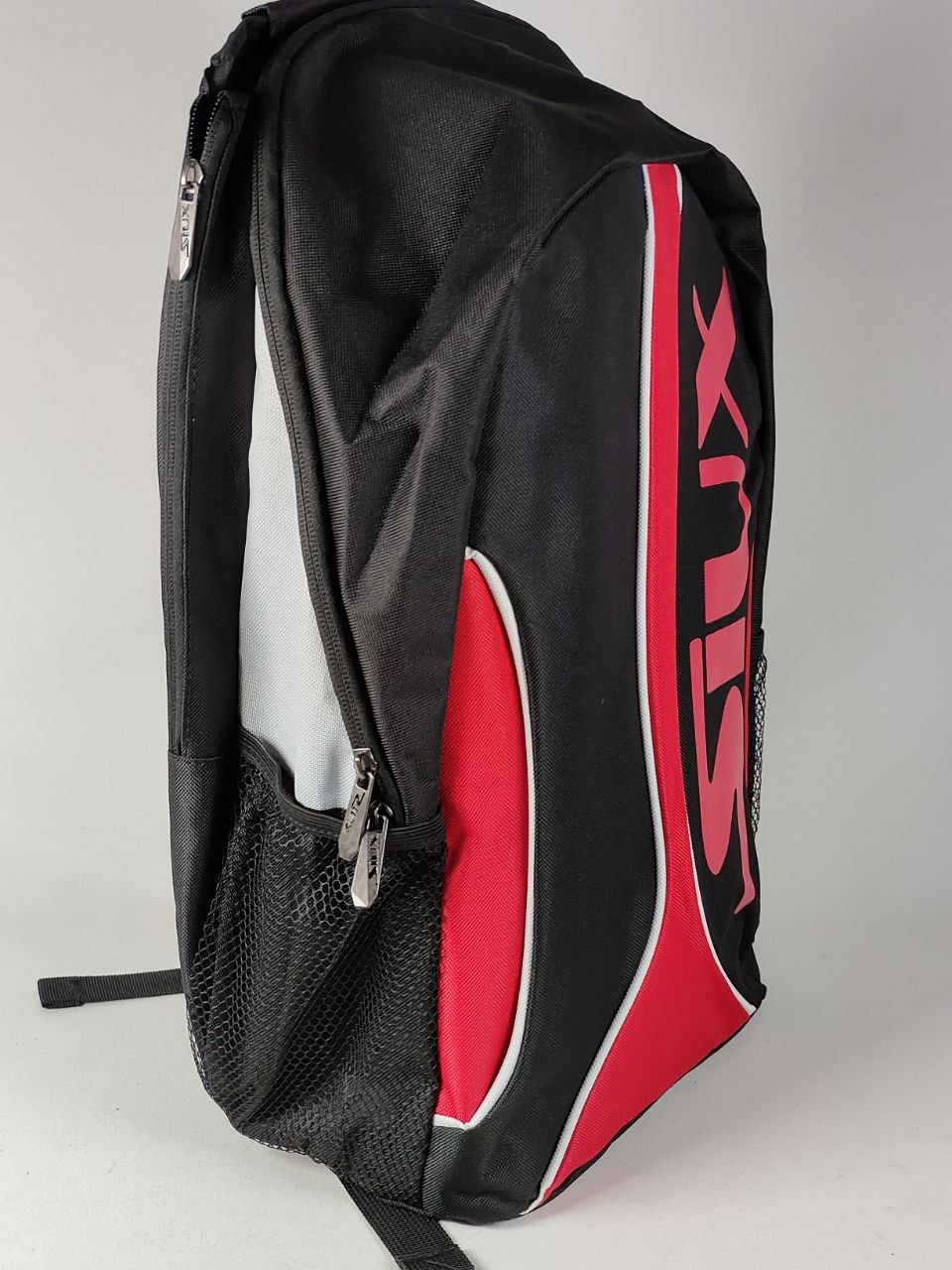 Black and red backpack with a visible brand logo on a gray background